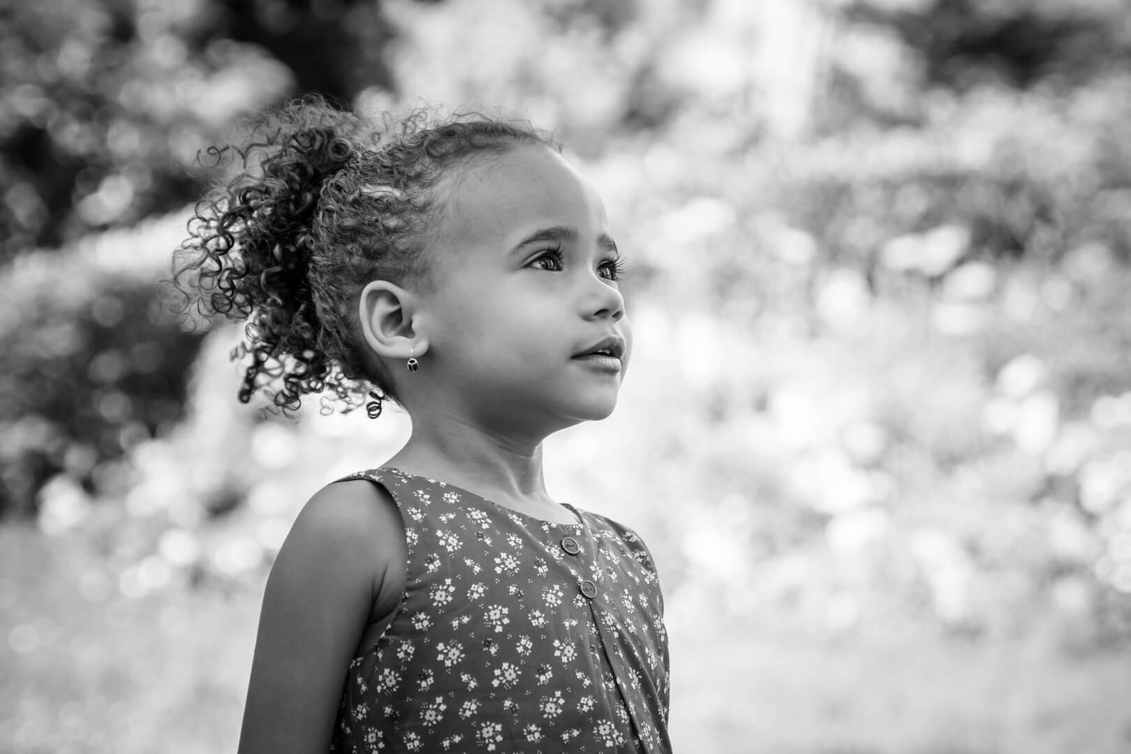 Portrait en noir et blanc d'une petite fille regardant le ciel
